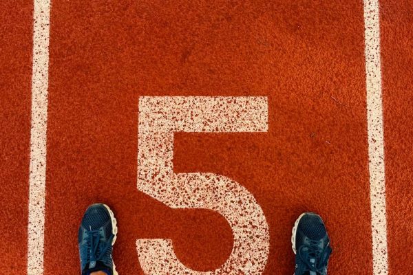 Runner's feet on track lane 5 at the finish line, symbolizing completion and success.