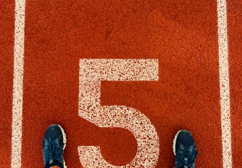 Runner's feet on track lane 5 at the finish line, symbolizing completion and success.